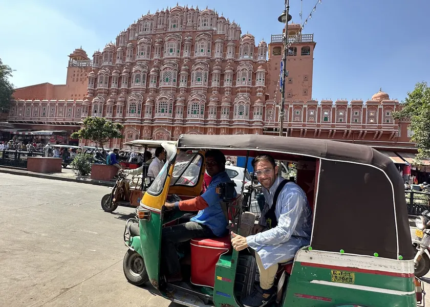 Guests riding in the green-and-yellow tuk-tuk through Jaipur